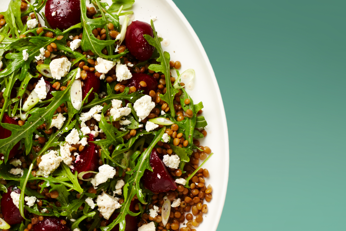Nutrition Australia's Beetroot, Lentil and Feta Salad served in a whilte plate, sitting on a white tea towel, one white wood.