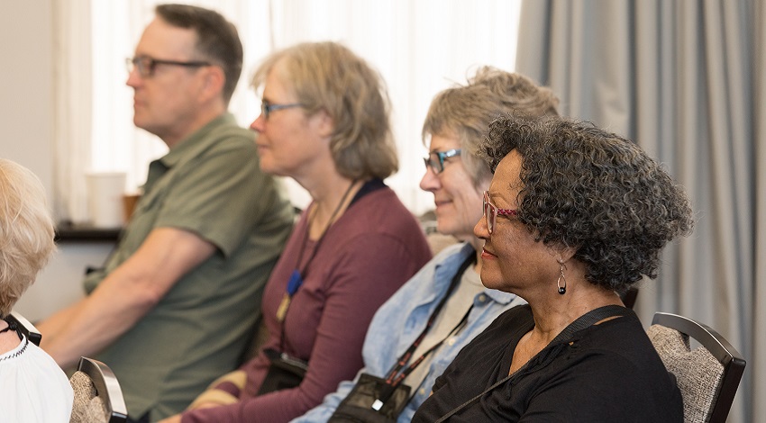 Four Road Scholars sit and listen in a classroom setting