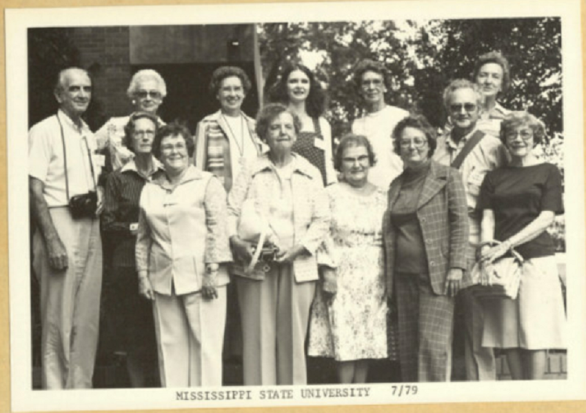 Road Scholars smile for the camera in a black and white photo at Mississippi State University