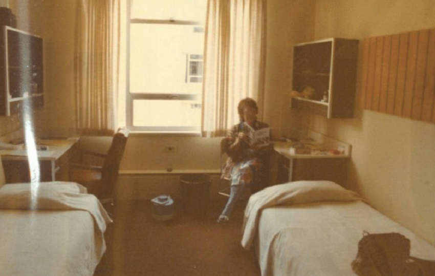 A Road Scholar sits in a dorm room reading