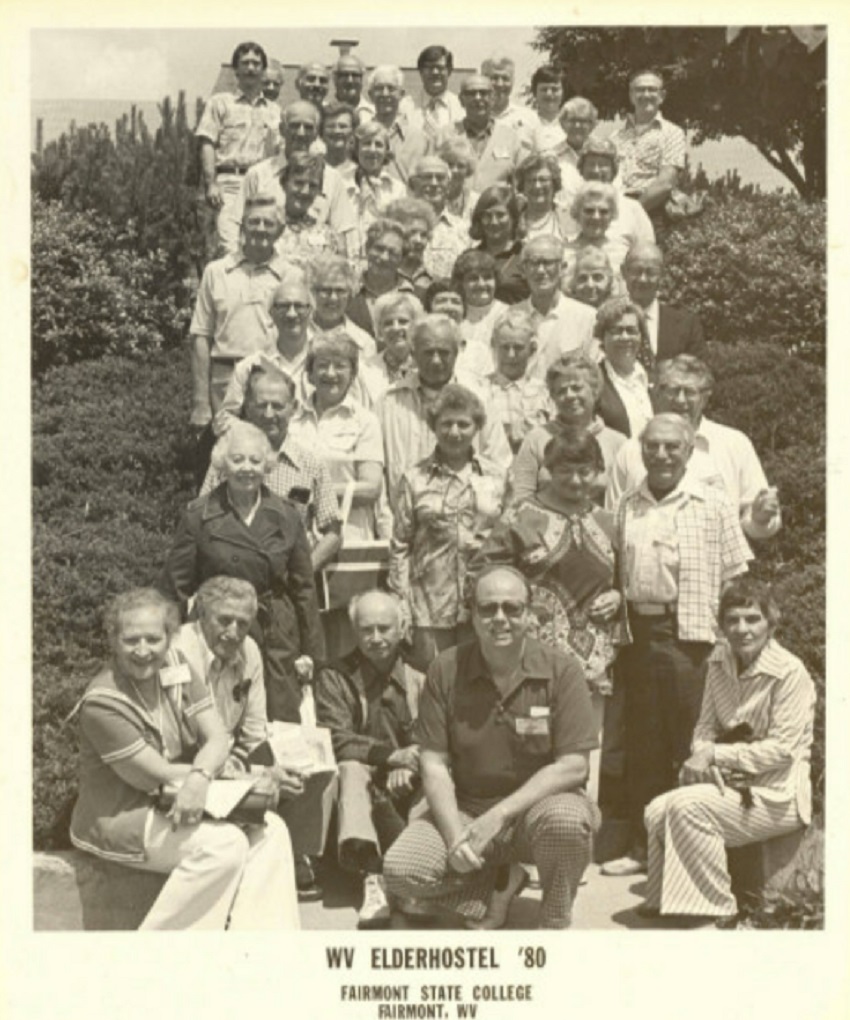 In a black and white photo, Road Scholars pose on a staircase and smile at the camera
