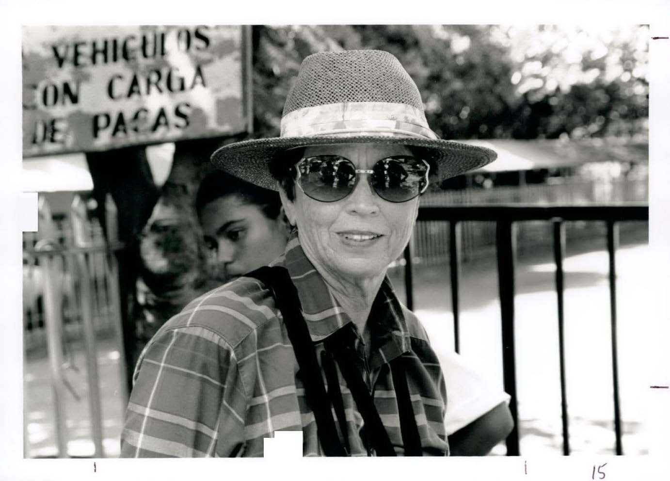 A woman wearing sunglasses and a wide-brim hat smiles at the camera in Costa Rica