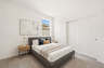 bedroom with a full-sized bed, a grey bedframe, and oak nightstands