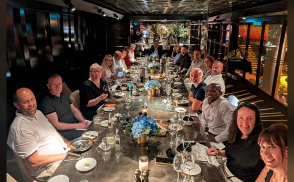 Large group of volunteers seated at large table in restaurant