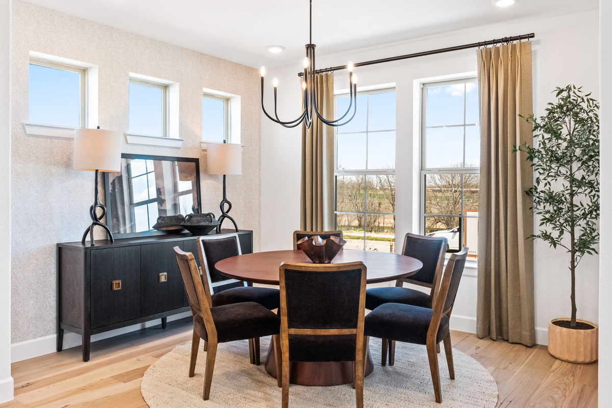 open dining room with wood floors and windows