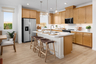 kitchen with light wood cabinets & floors, white counters, window, and stainless-steel refrigerator