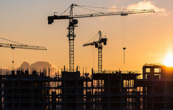 Building cranes at sunset