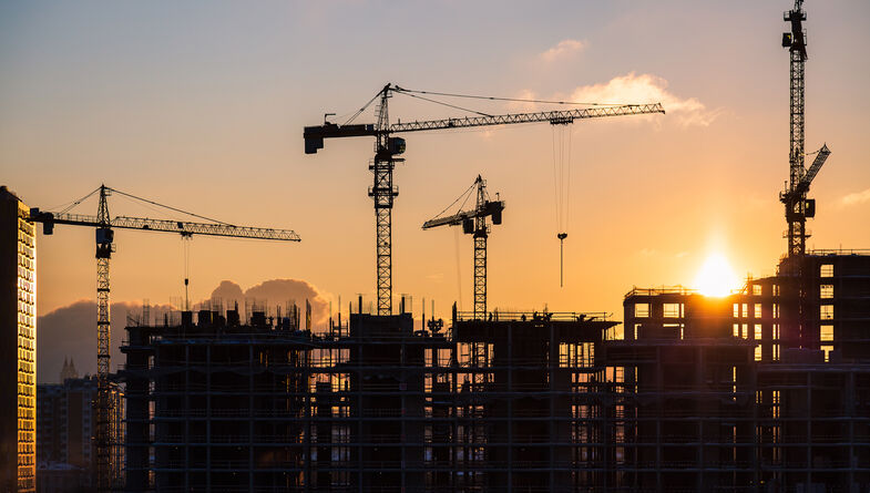 Building cranes at sunset