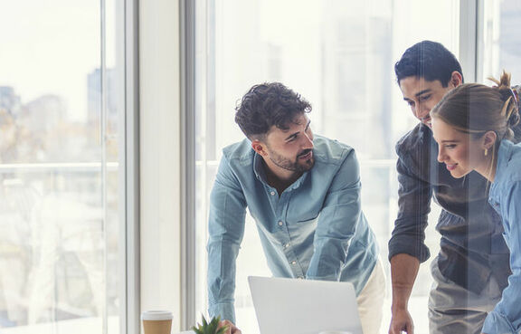 Business professionals having casual meeting over laptop