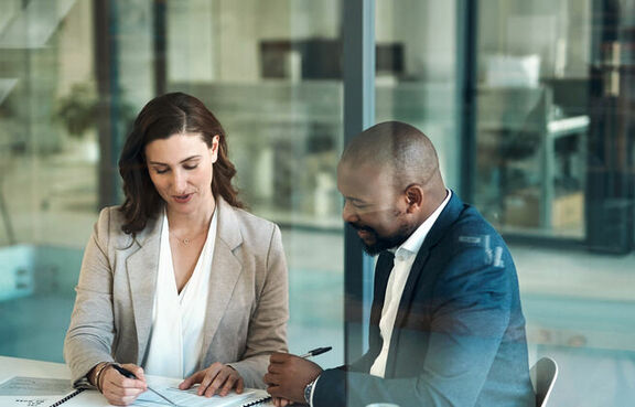 Co-workers sitting at a table looking over financial documents