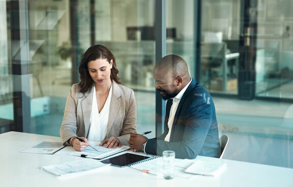Co-workers sitting at a table looking over financial documents
