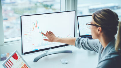 Business woman studying financial charts on computer