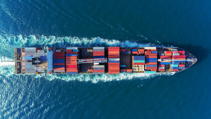 Top down look at loaded cargo ship moving through water