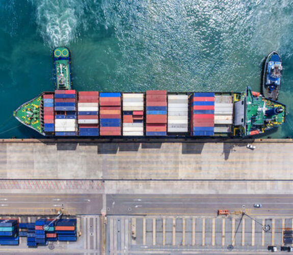 Cargo ship full of containers docking in a harbor