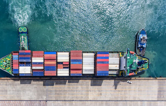 Cargo ship full of containers docking in a harbor