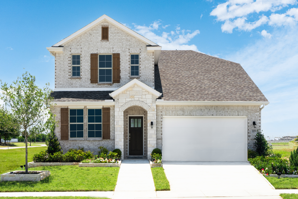 brick and stone exterior with tree in front yard
