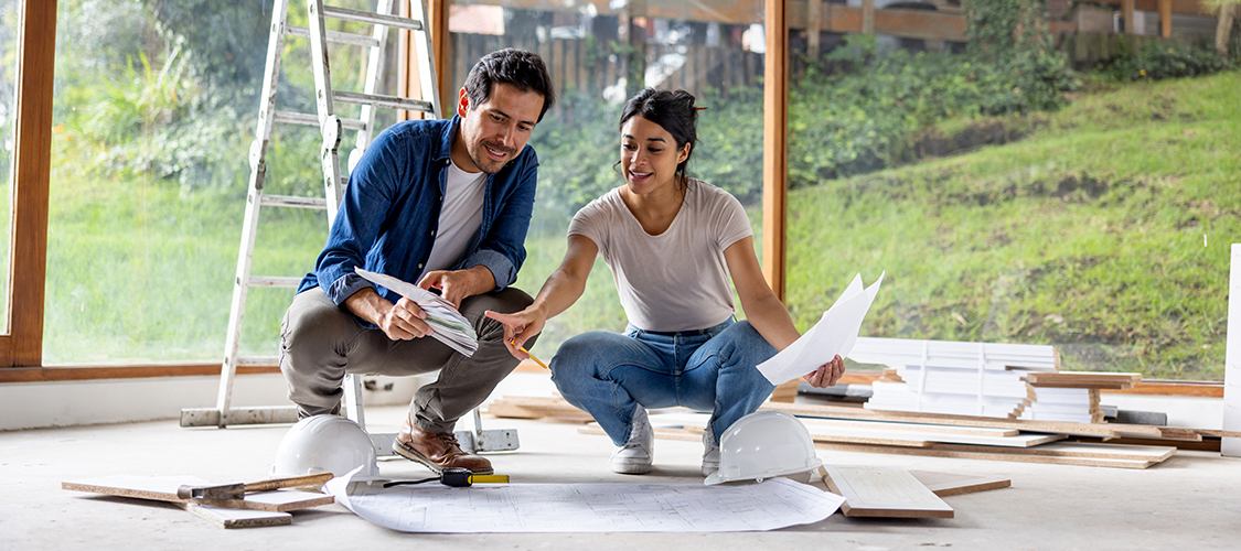 A Hispanic woman and man go over remodeling plans
