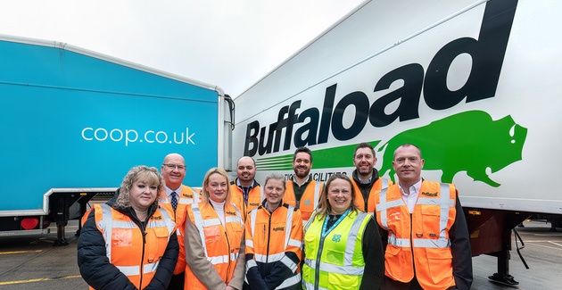 9 people in high-vis jackets standing in front of two trucks. The truck on the left is Co-op branded with a light blue background, and the truck on the right has Buffaload logo on it with a white background. The image depicts the partnership between the two companies.