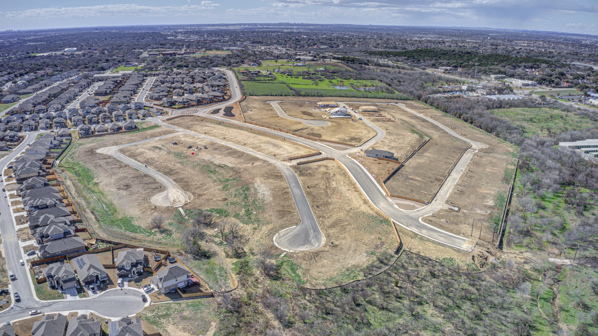 aerial view of the community with dirt & trees