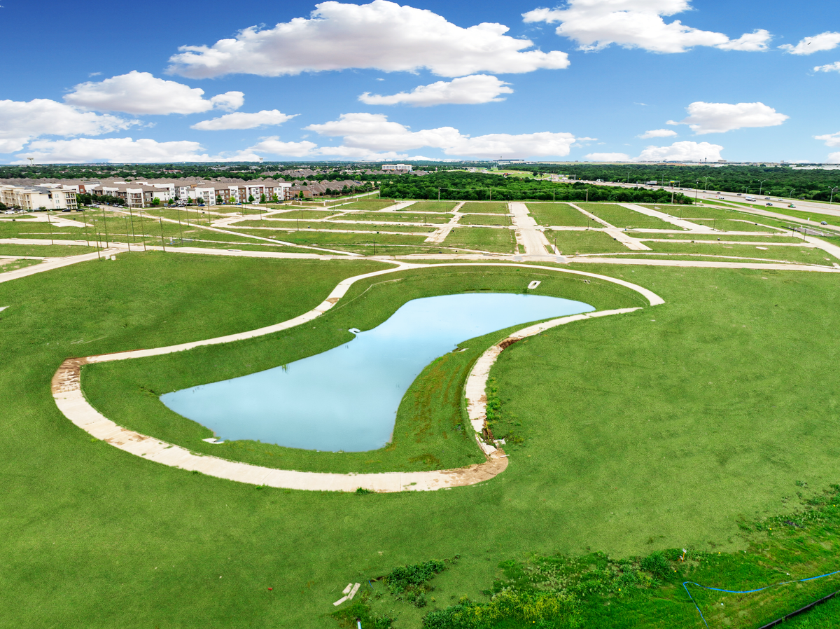 aerial photo of community land with grass and pond