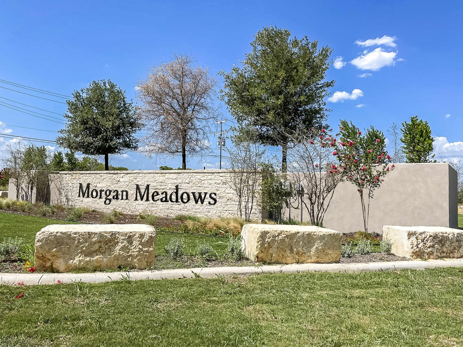 entrance with a stone sign & trees
