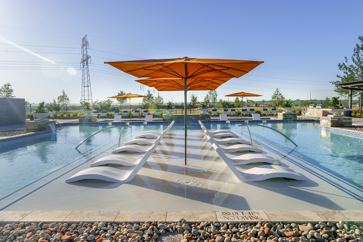 community pool with lounge changes and umbrellas