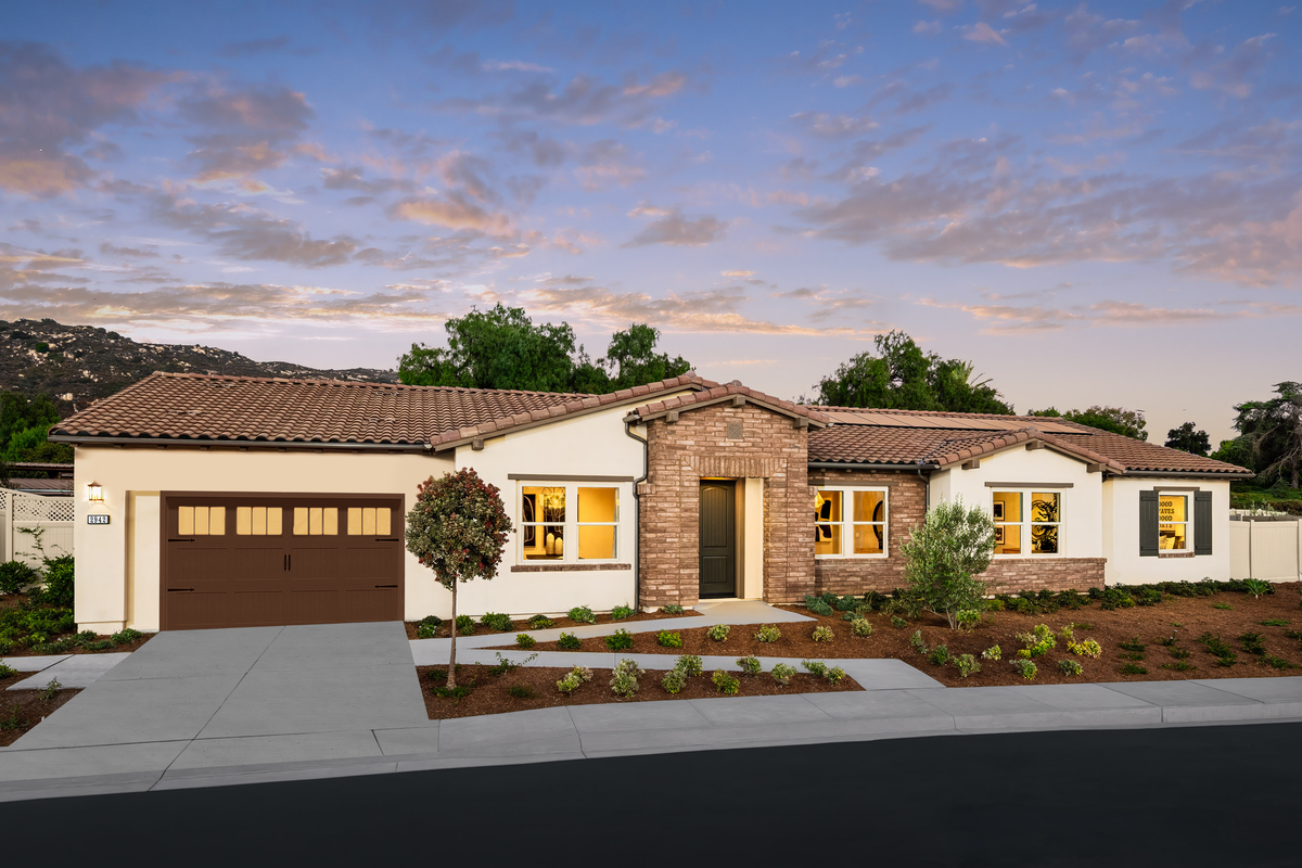 exterior of single-story home with desert landscaping and brown garage