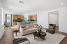 open-concept space with a large white couch, dark brown wooden coffee table, and dark green accent chair