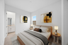 bedroom with a brown leather bedframe, white mattress covers, and brown nightstands