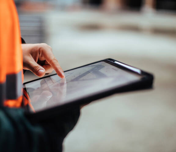 Construction worker using a tablet at a work site