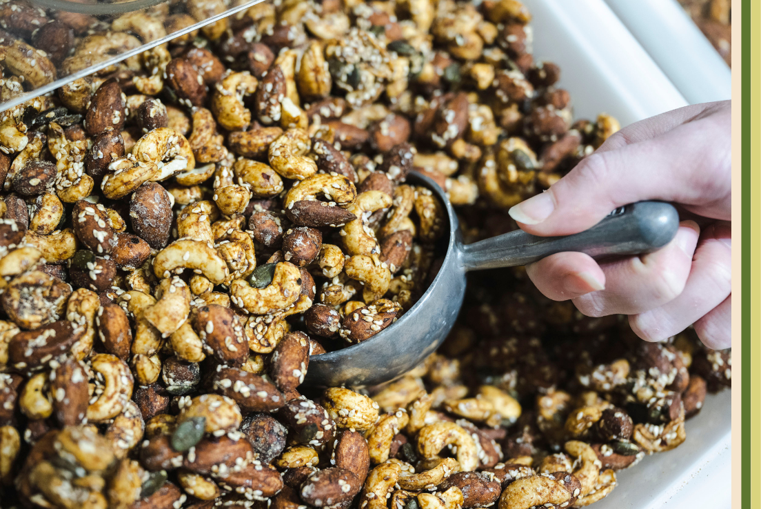 Close up image of customer self-scooping sesame coasted cashew and almond mix