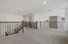 Loft with oak tread and iron railing, carpet, and large windows