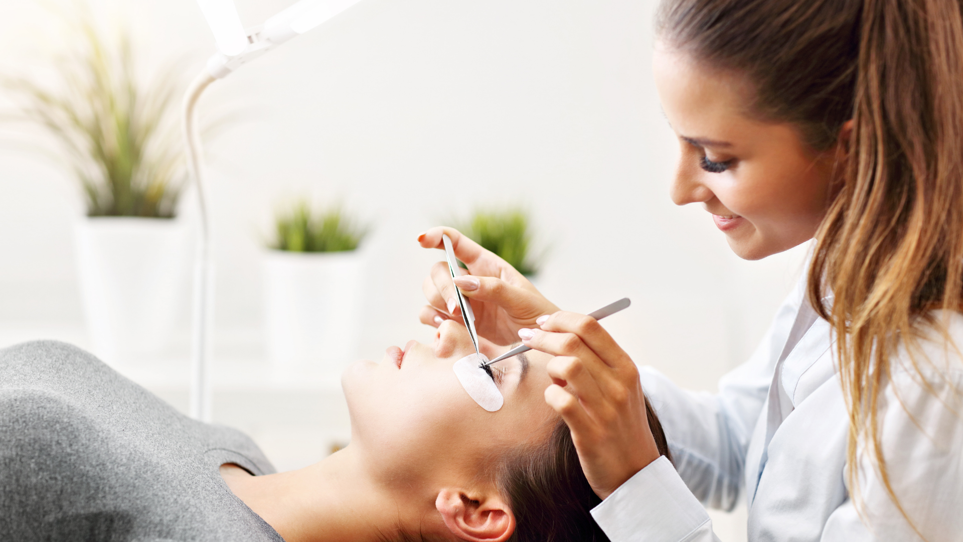 Woman receiving eyelash extensions at a beauty salon