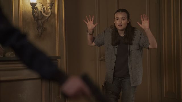 Ellie with her hands up at gunpoint.jpg
