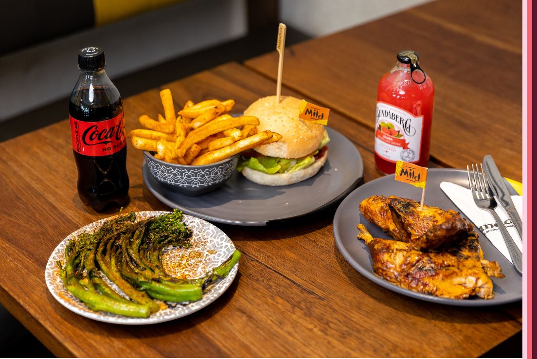 A variety of dishes including burger, chips, chicken and greens from Nandos. 