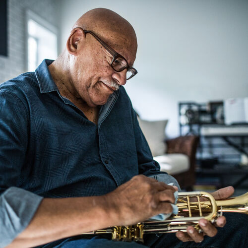 Musician wearing occupational glasses cleaning trumpet