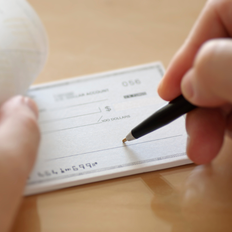 Image of a cheque being signed