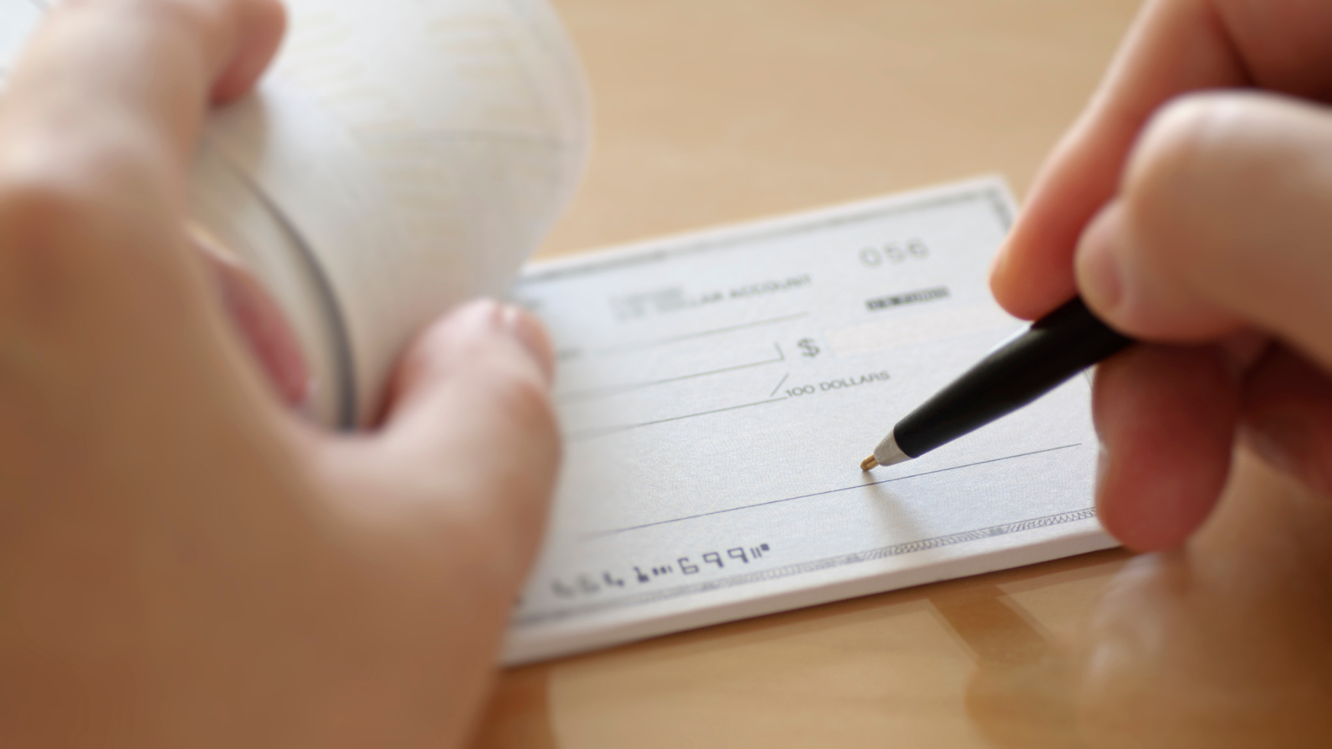 Image of a cheque being signed