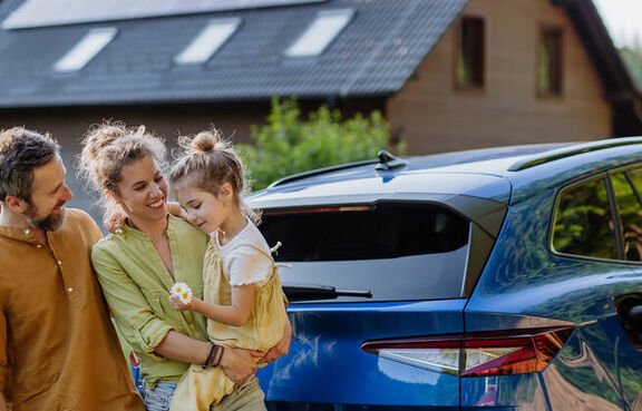 Family standing in front of an electric vehicle