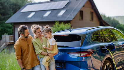 Family standing in front of an electric vehicle
