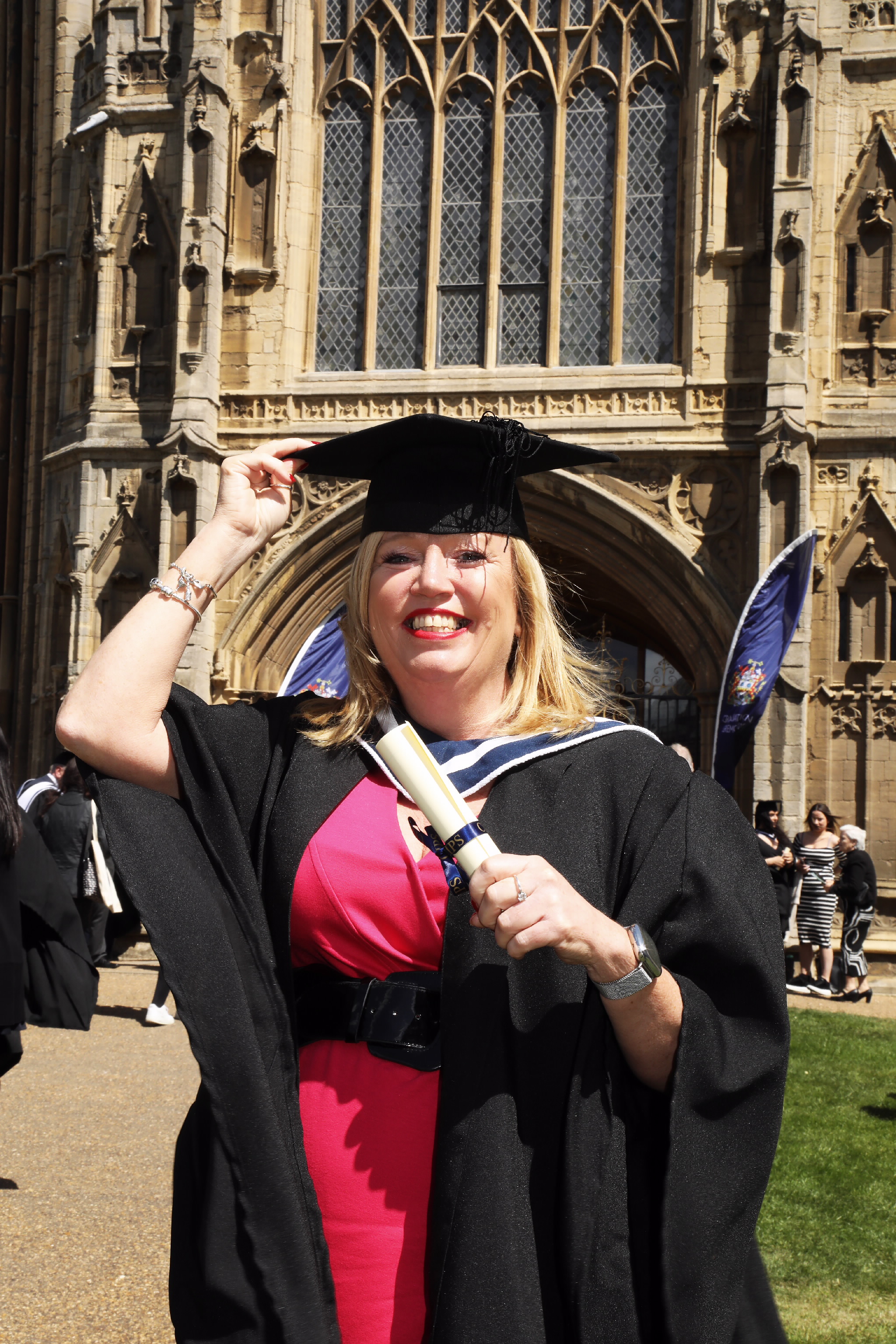 Female graduate holding a diploma outside the cathedral
