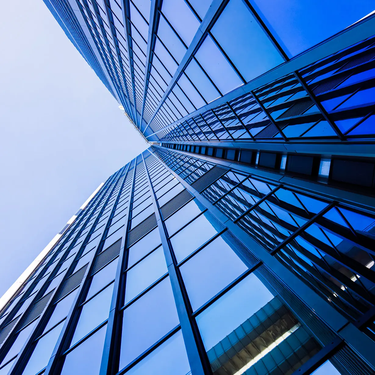 Looking up at a tall modern skyscraper with reflective glass windows