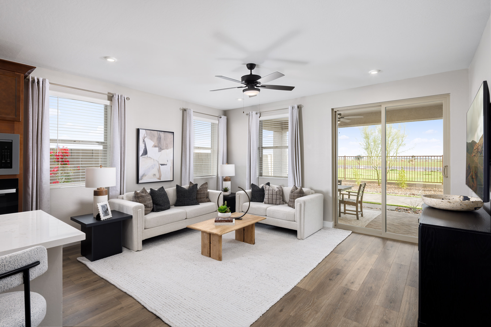 open-concept space with a large white couch, wooden coffee table and white rug
