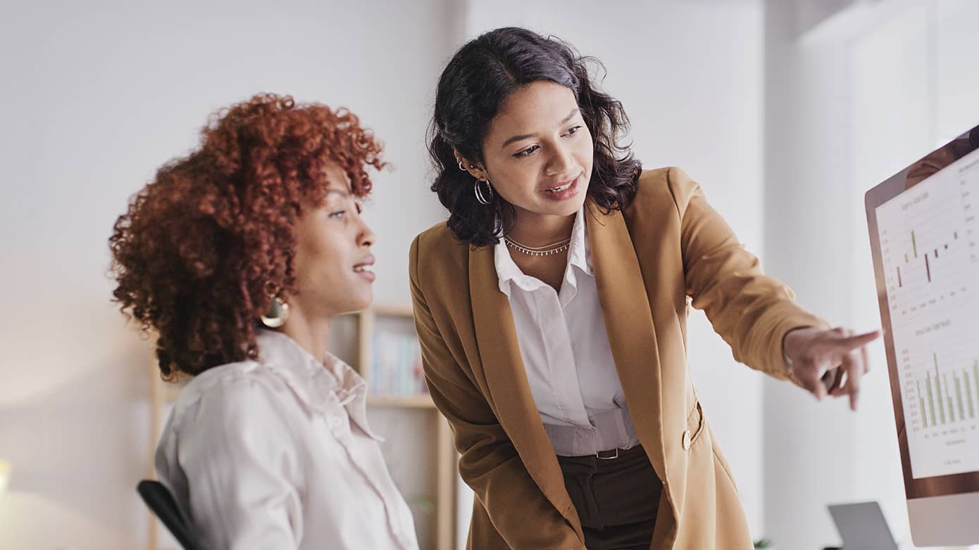 Two women looking at a computer screen.