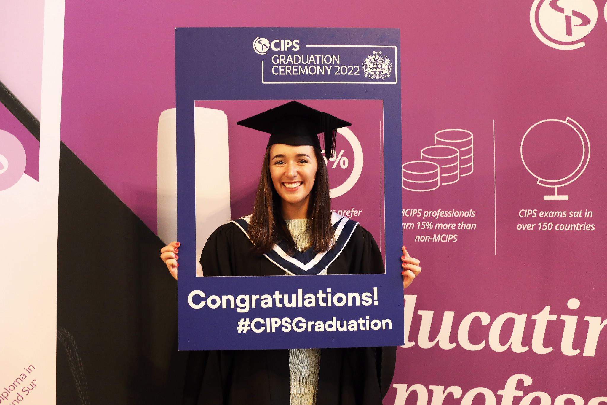 Graduate poses with a CIPS photo frame