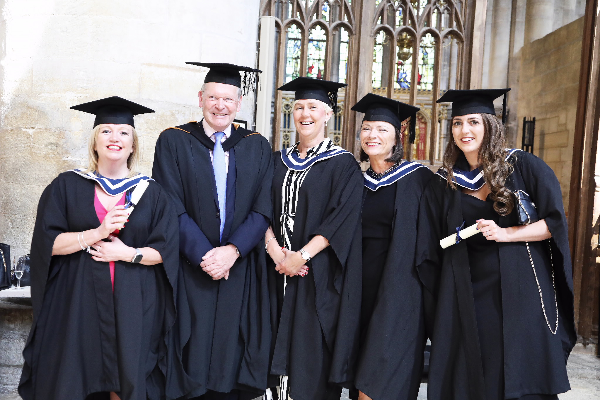 Group of five graduates posing together for a photo