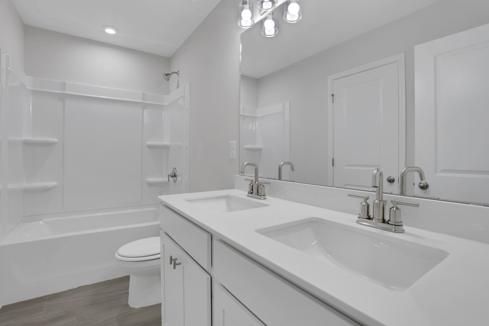 secondary bathroom with white cabinets and tile flooring
