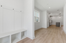 entryway with white valet bench with hooks for storage