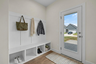 mud room with glass door, wood floors, and a valet bench with hooks