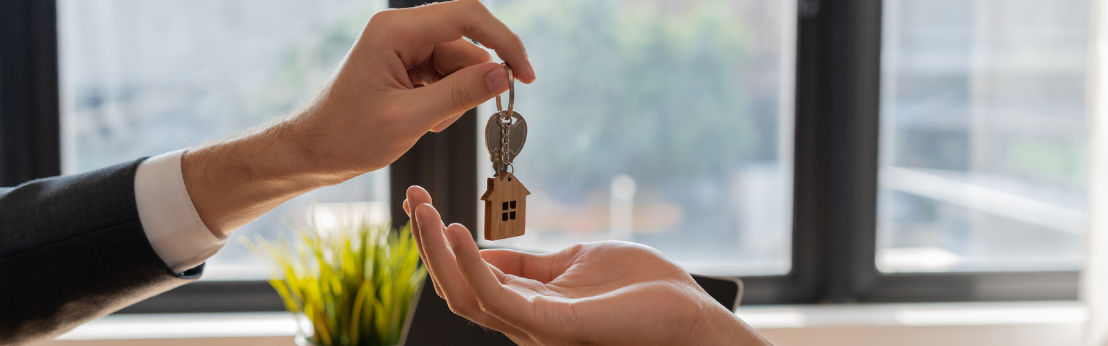One person handing a house key to another